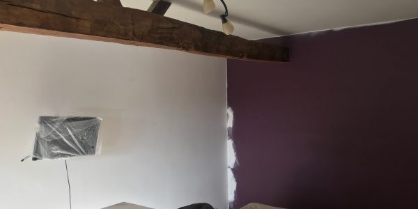 purple wall with wooden beam
