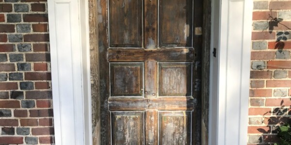 white frame with unpainted front door