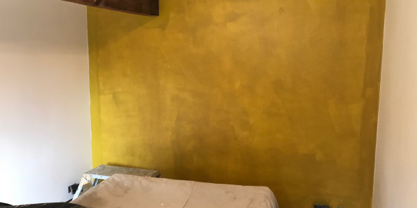 mustard wall with brown wooden beam